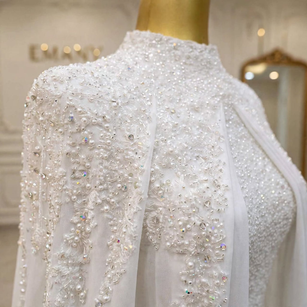 Close-up of the crystal and pearl beadwork on the Aurelia modest wedding gown with chiffon cape by EMANY
