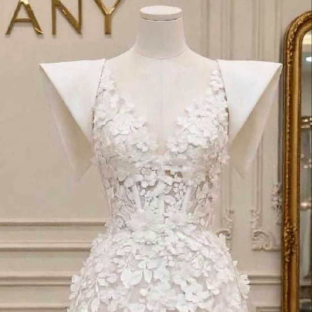 Close-up detail of the Florence wedding dress showing intricate 3D floral embroidery, delicate spaghetti straps, and an illusion bodice.

