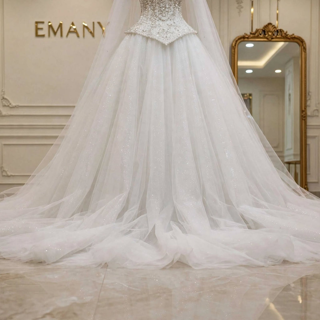 Close-up of the glitter tulle skirt and long sweeping train on the Giselle bridal gown by EMANY.