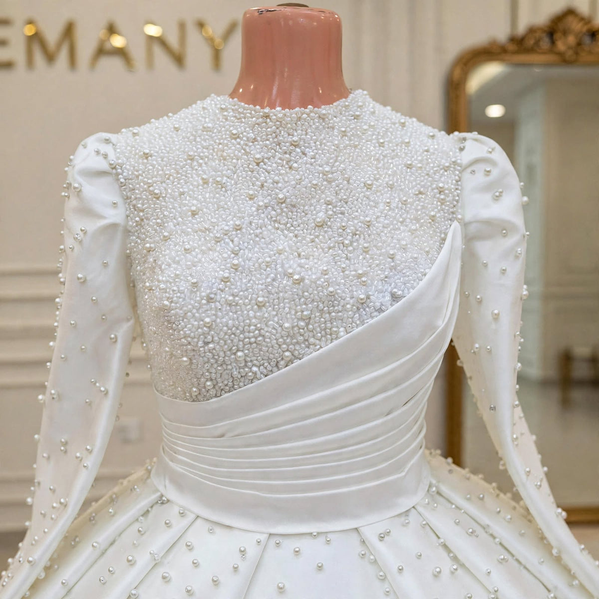 Close-up of the dense pearl beading and draped satin waist on the Marguerite bridal gown.