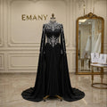 Front full view of the Noor Noir modest black mermaid gown with dramatic cape sleeves by EMANY.

