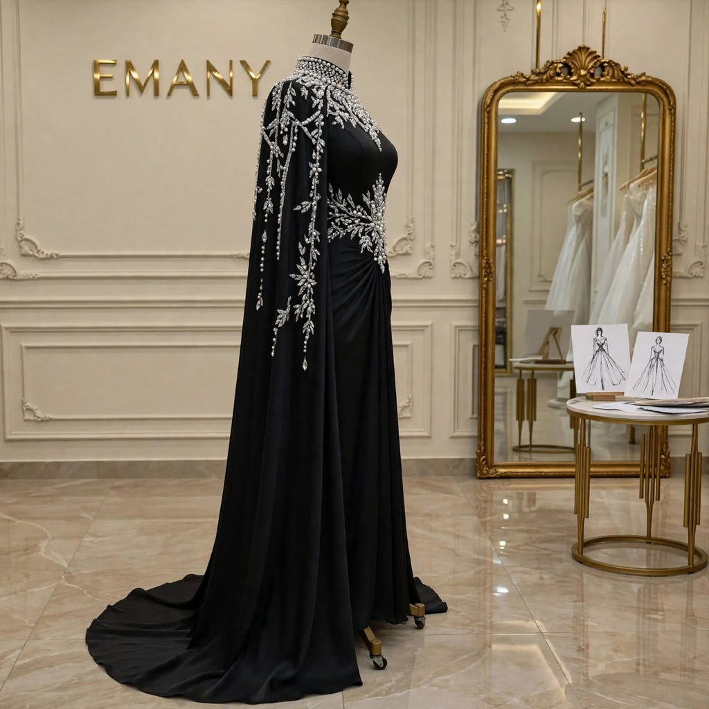 Side profile of the Noor Noir black satin gown, showing the draped waist and long, elegant cape sleeves.

