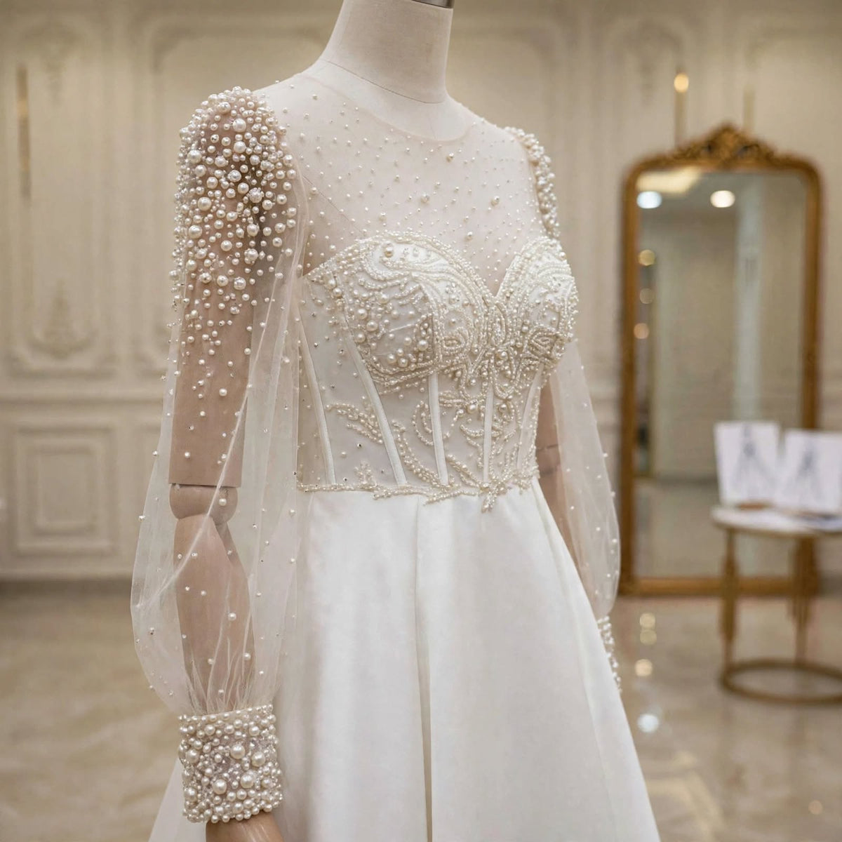 Close-up of the sheer puff sleeves with pearl detailing and heavy pearl cuffs on the Rosalind gown.