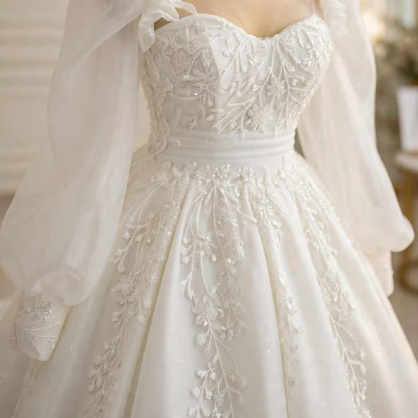 Close-up of the Seraphina wedding dress bodice, featuring sweetheart illusion neckline, delicate beadwork, and cascading floral lace embroidery.


