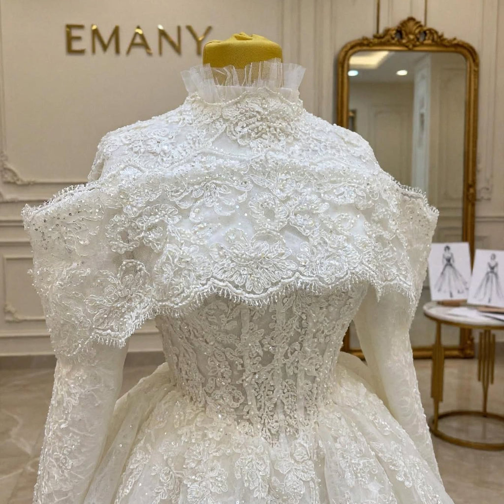 Close-up detail of the Victoria wedding dress showing the intricate pearl and crystal embroidery on the high-neck bodice and the detached lace capelet.


