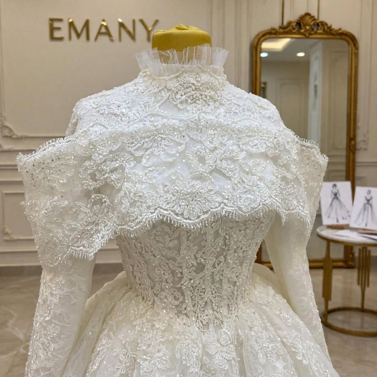Close-up detail of the Victoria wedding dress showing the intricate pearl and crystal embroidery on the high-neck bodice and the detached lace capelet.


